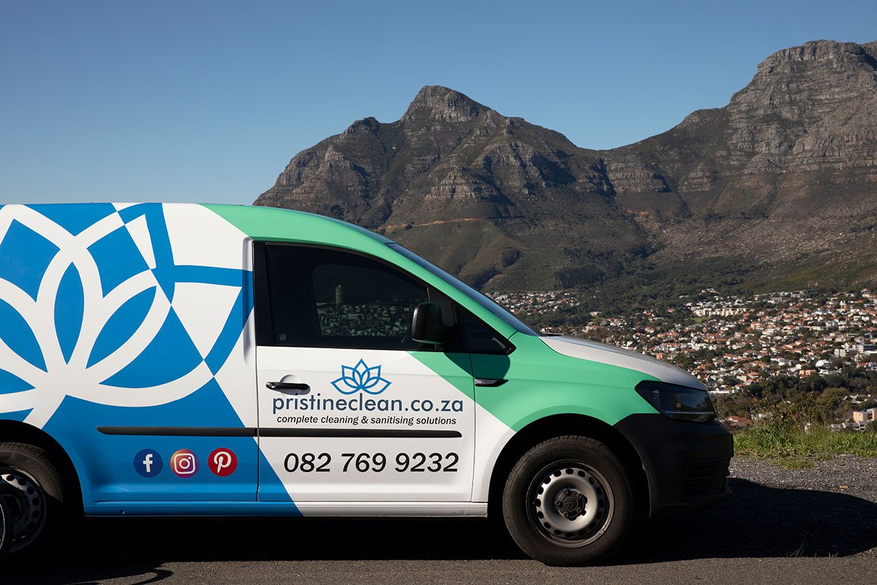 The Pristine Clean van with its lotus wrap, parked above Cape Town with the mountain behind